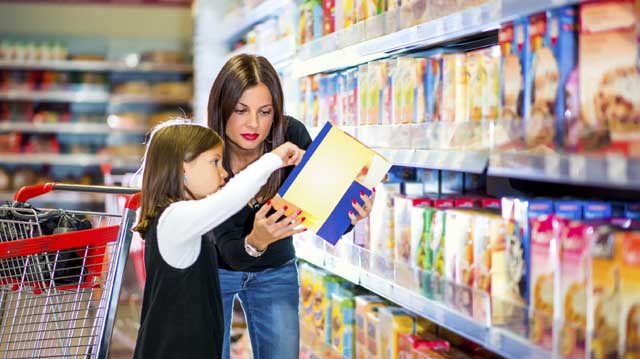 Mother and daughter checking food labeling in supermarket